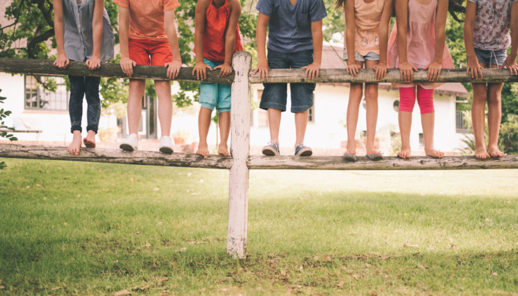 Niños en una valla de madera