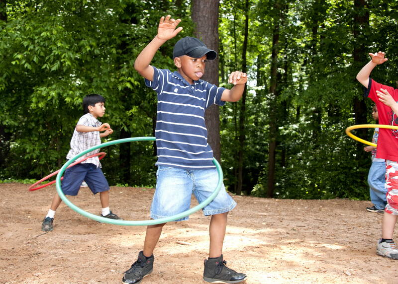 Un niño bailando el aro al aire libre