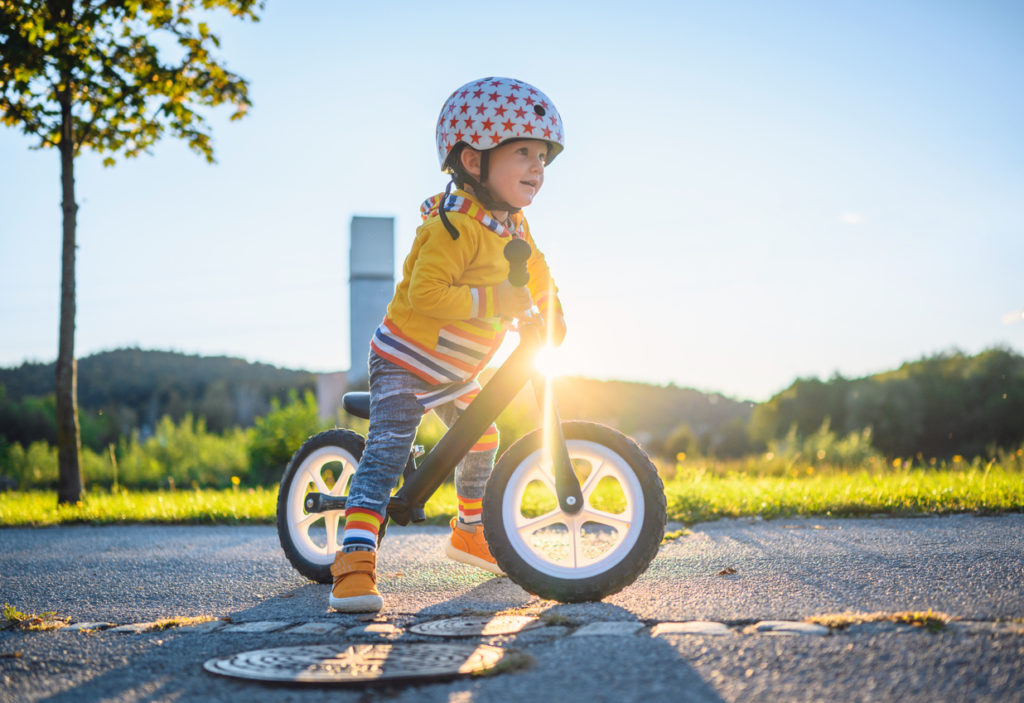 Un niño aprendiendo a montar en bicicleta con una bicicleta sin pedales