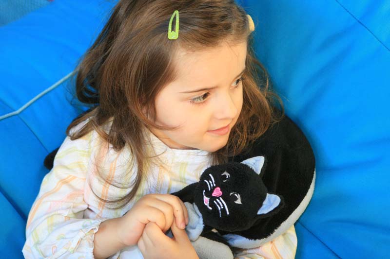 niña con gato de peluche lastrado 