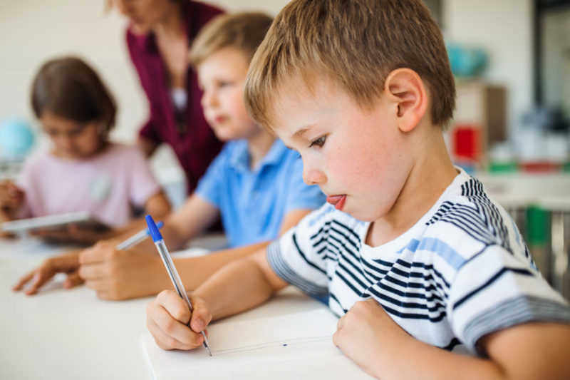 Niño concentrado aprendiendo a escribir