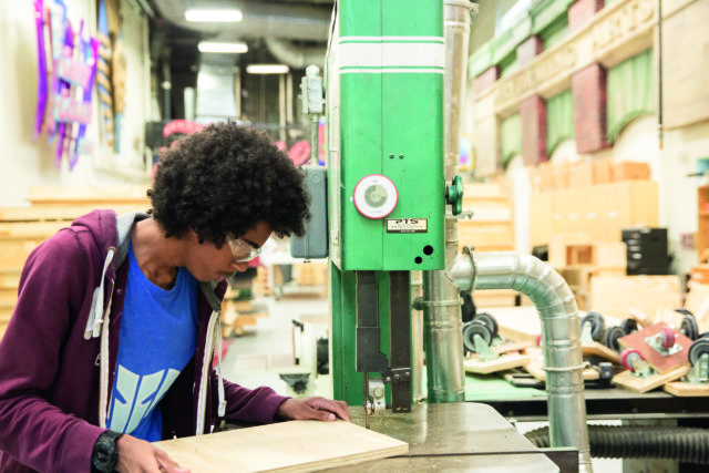 un joven trabajando en un taller de madera