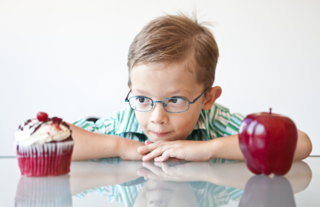 Un nino duda entre manzana o pastel