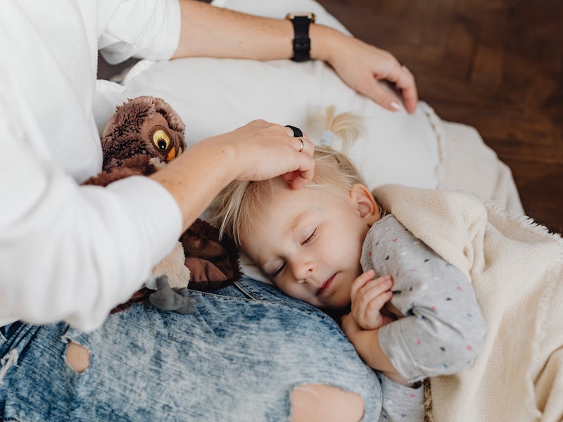 un niño duerme en las piernas de su madre